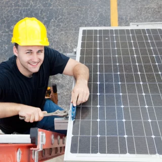 técnico sorridente fazendo a instalação de um painel fotovoltaico